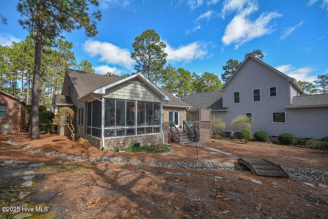 rear view of house featuring a sunroom