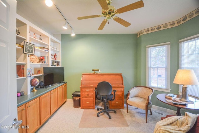 office area with visible vents, baseboards, light colored carpet, and a ceiling fan