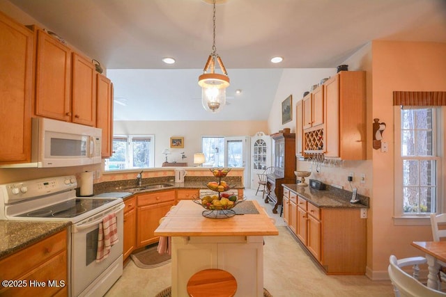 kitchen featuring white appliances, a peninsula, a sink, pendant lighting, and wood counters