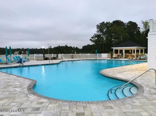 pool featuring a gazebo, a patio area, and fence