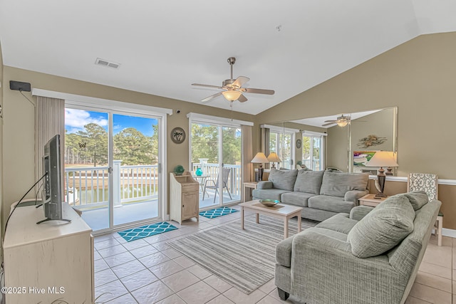 living area featuring ceiling fan, a healthy amount of sunlight, vaulted ceiling, and light tile patterned floors