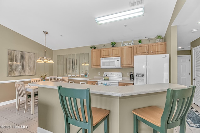 kitchen with white appliances, light countertops, a kitchen breakfast bar, and light tile patterned flooring