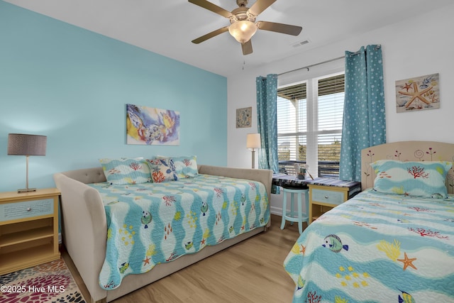 bedroom featuring wood finished floors, visible vents, and ceiling fan