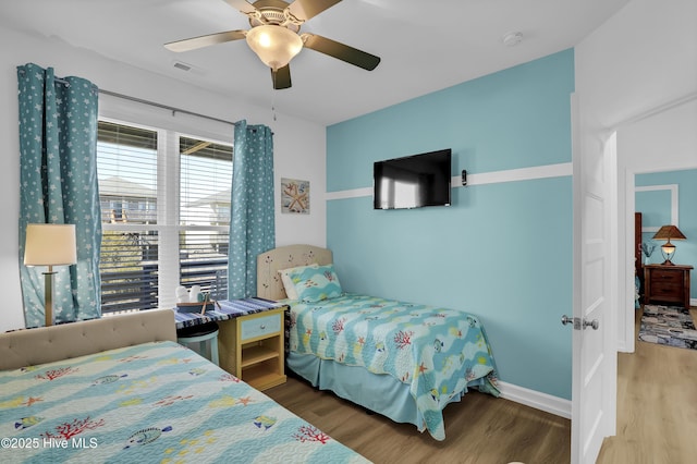 bedroom with visible vents, baseboards, a ceiling fan, and wood finished floors