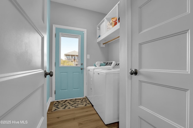 laundry area with light wood-style floors, separate washer and dryer, and laundry area