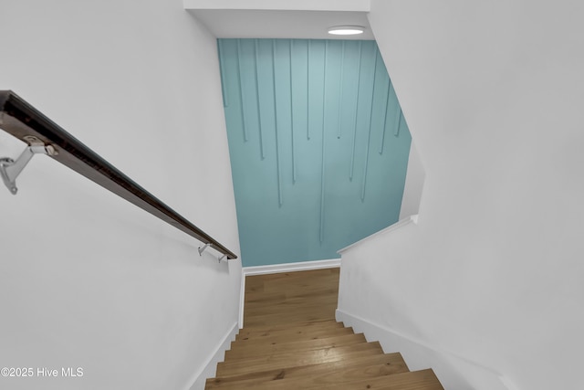 stairway featuring baseboards and wood finished floors