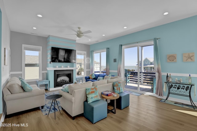 living area featuring a fireplace, wood finished floors, recessed lighting, and a ceiling fan