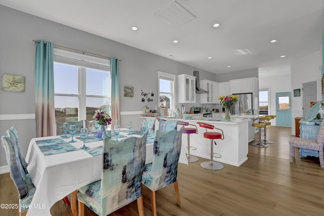 dining space with recessed lighting, a healthy amount of sunlight, and light wood-style flooring