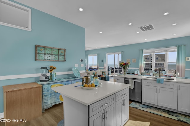 kitchen with visible vents, light wood finished floors, plenty of natural light, stainless steel dishwasher, and light countertops