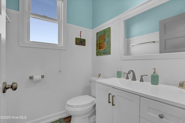 bathroom featuring vanity, toilet, and baseboards