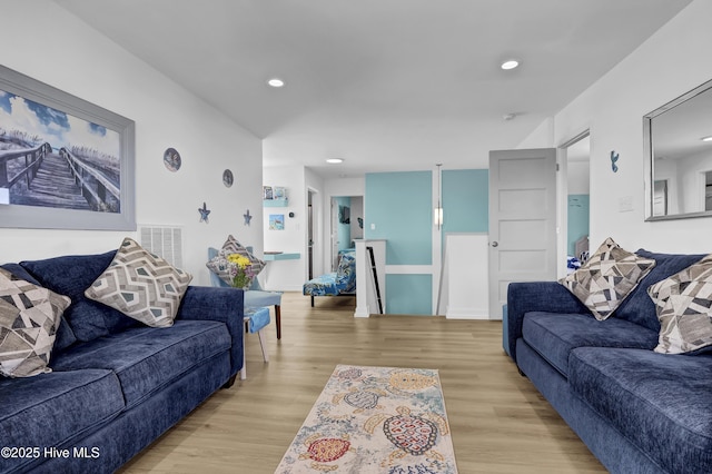 living area with visible vents, recessed lighting, and wood finished floors