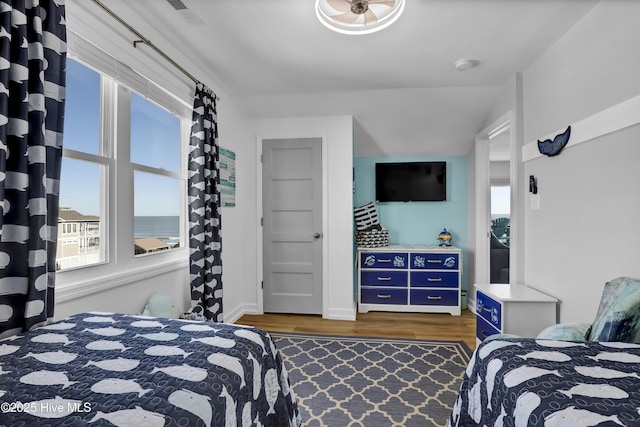 bedroom with visible vents, baseboards, and dark wood finished floors