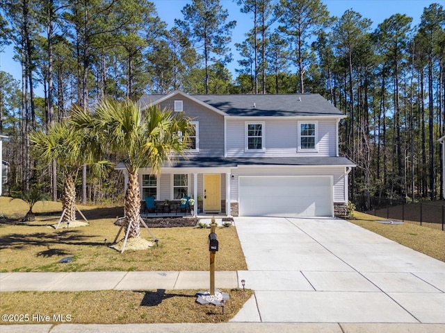 traditional home featuring covered porch, driveway, a front lawn, and stone siding