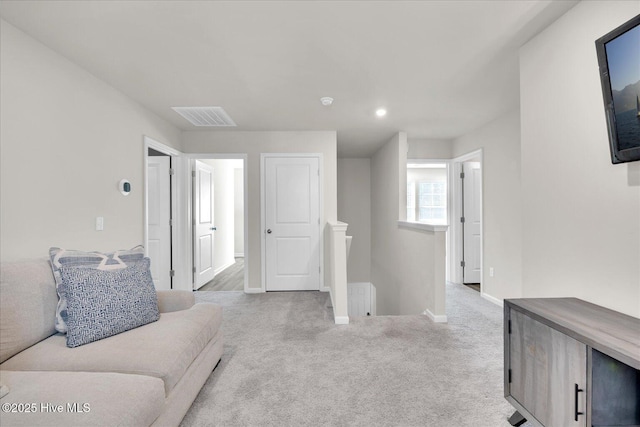 living room featuring carpet, visible vents, and baseboards