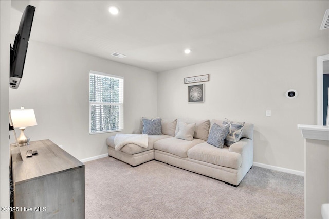 carpeted living area with recessed lighting, visible vents, and baseboards