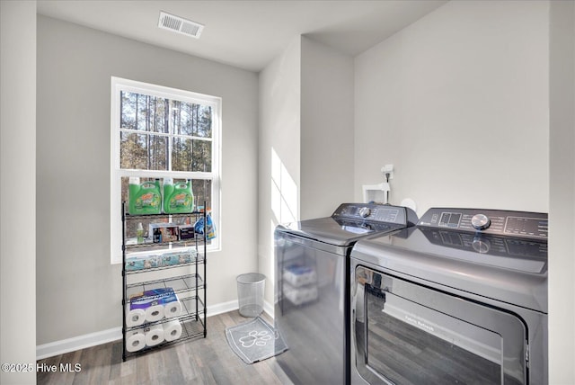 laundry room featuring laundry area, baseboards, visible vents, wood finished floors, and independent washer and dryer