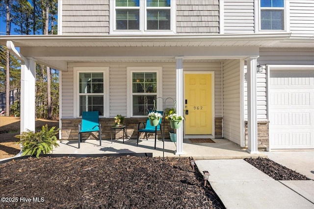 property entrance featuring stone siding and covered porch