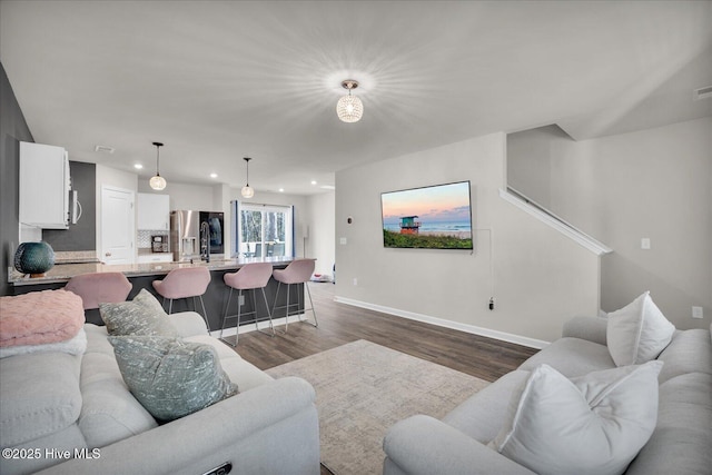 living area with dark wood-style floors, baseboards, and recessed lighting