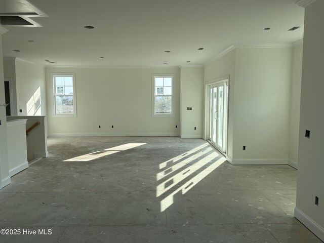 empty room featuring crown molding and baseboards