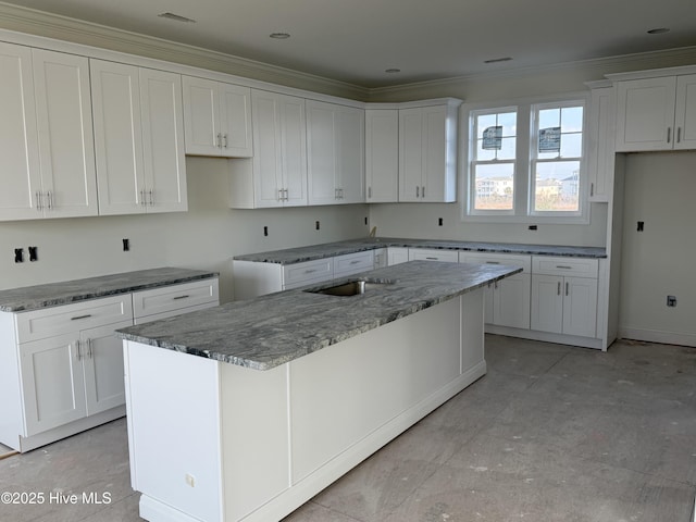 kitchen featuring stone counters, crown molding, a kitchen island, and white cabinetry