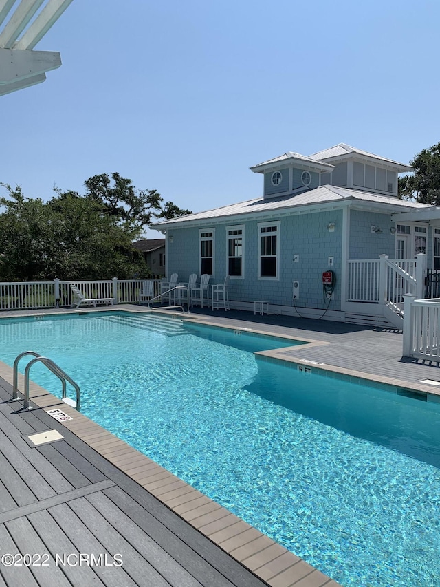 pool with a patio and fence