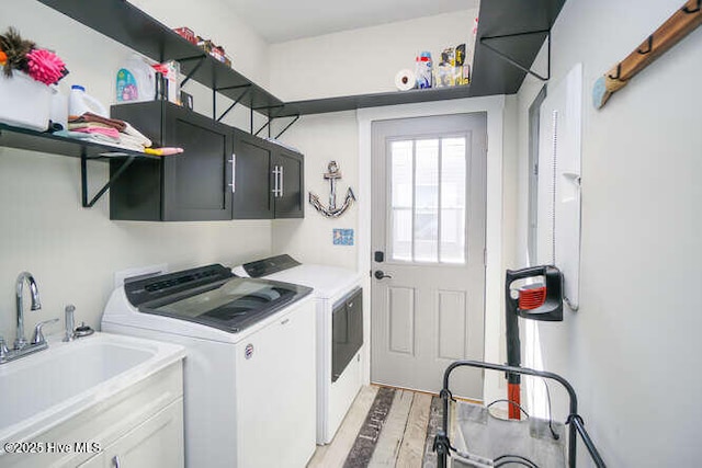 226 NE 76th St, Oak Island, NC 28465 - laundry room with washer and clothes dryer, cabinet space, and light wood-style floors