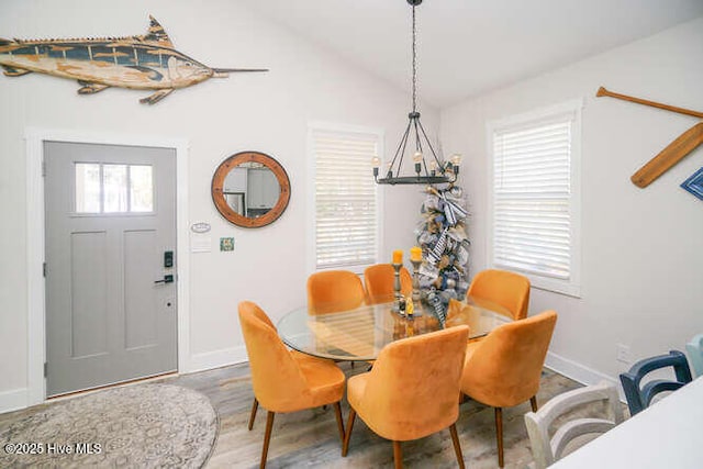 226 NE 76th St, Oak Island, NC 28465 - dining space with a chandelier, baseboards, vaulted ceiling, and wood finished floors