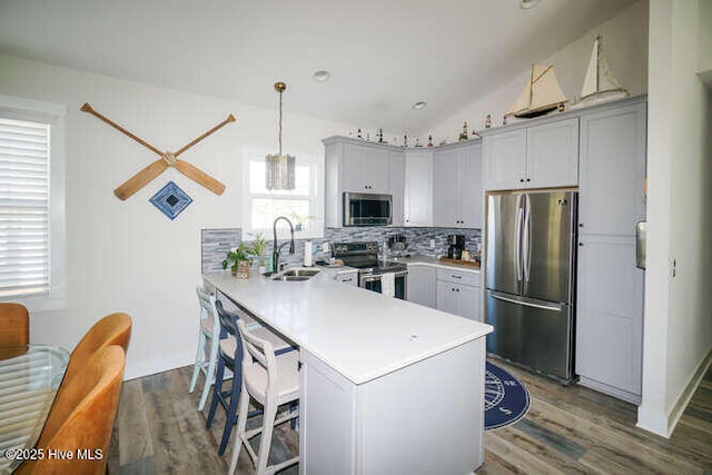 226 NE 76th St, Oak Island, NC 28465 - kitchen with stainless steel appliances, a sink, a peninsula, light countertops, and wood finished floors
