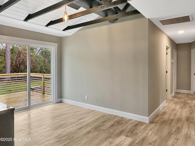 spare room with visible vents, vaulted ceiling with beams, light wood-type flooring, and baseboards