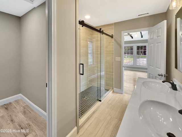 full bath with baseboards, a stall shower, and a sink