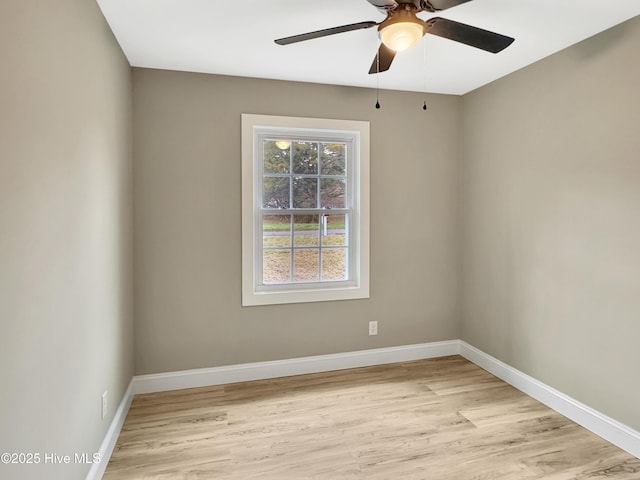 spare room featuring baseboards, light wood-style floors, and ceiling fan