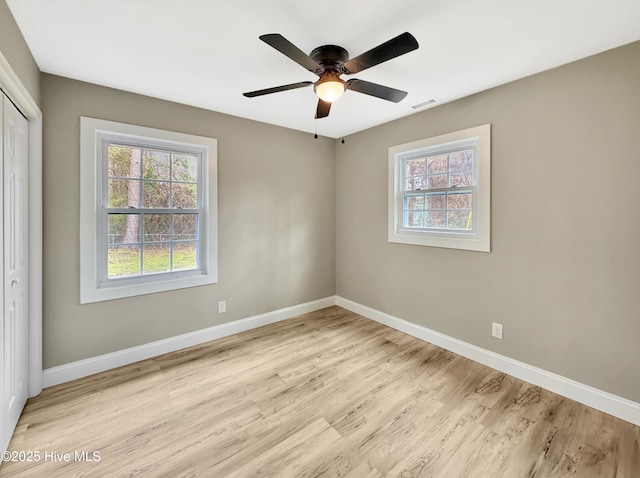 spare room with visible vents, baseboards, ceiling fan, and light wood finished floors