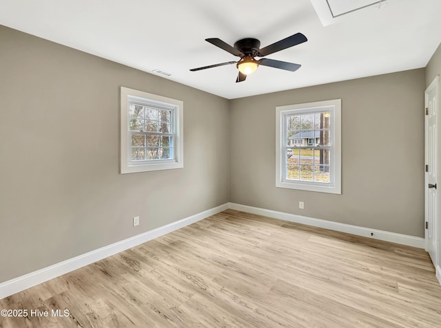 spare room with visible vents, a ceiling fan, light wood-type flooring, and baseboards