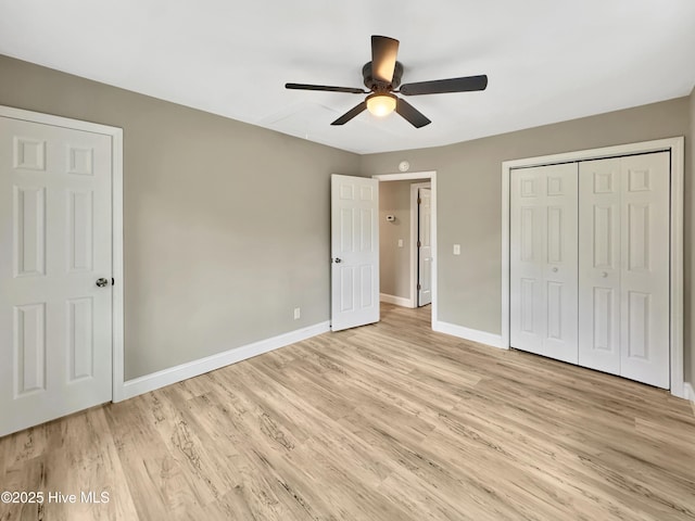 unfurnished bedroom with ceiling fan, baseboards, a closet, and light wood-type flooring