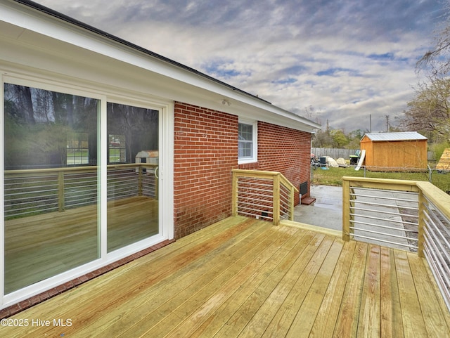 deck featuring a storage shed, an outdoor structure, and fence