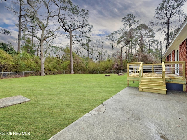 view of yard with a deck, a patio, and a fenced backyard