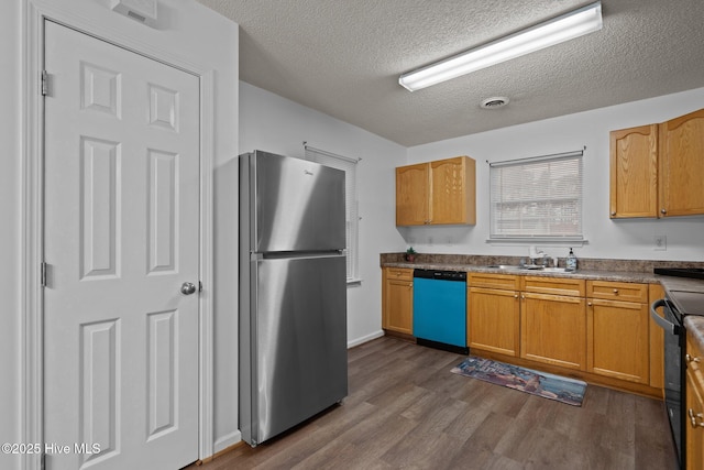 kitchen with black range with electric cooktop, a sink, freestanding refrigerator, dishwasher, and dark wood finished floors