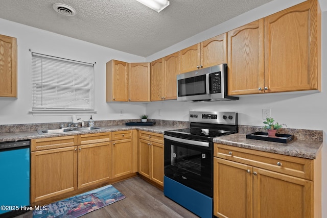 kitchen with range with electric stovetop, a sink, visible vents, dishwasher, and stainless steel microwave