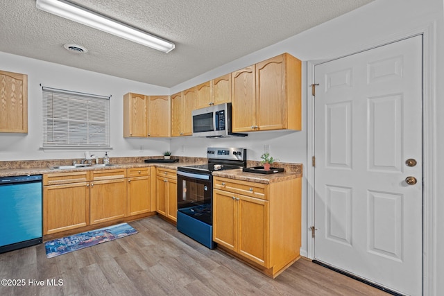 kitchen with visible vents, appliances with stainless steel finishes, a sink, a textured ceiling, and light wood-type flooring