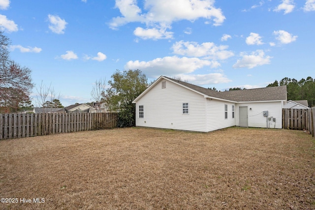 back of property featuring a yard and a fenced backyard