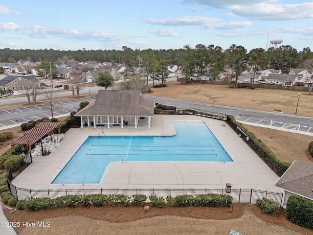 pool with a residential view, a patio area, and fence