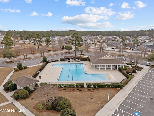 community pool featuring a residential view, a patio, and fence