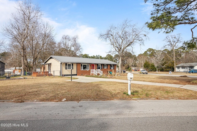 view of front of house with brick siding, crawl space, and a front yard