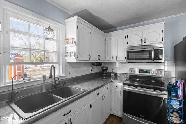 kitchen featuring appliances with stainless steel finishes, backsplash, a sink, and white cabinets