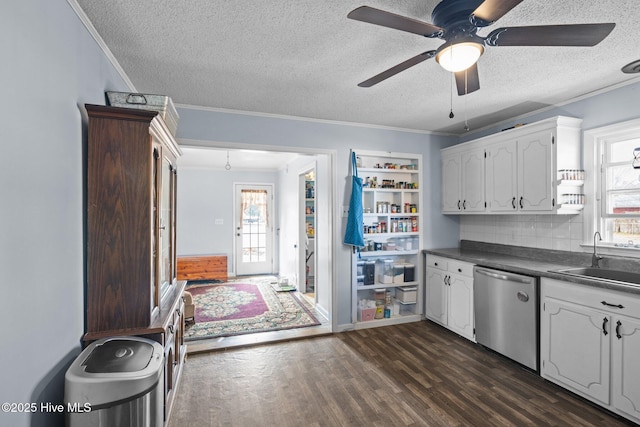 kitchen featuring a sink, white cabinetry, dishwasher, dark countertops, and dark wood finished floors