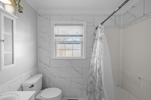 bathroom featuring shower / bath combination with curtain, ornamental molding, vanity, and toilet