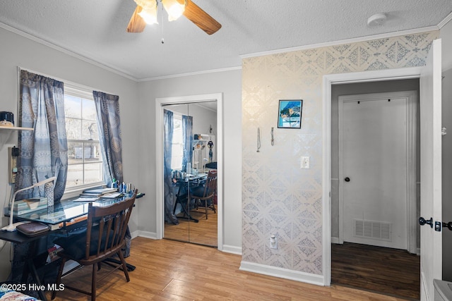 office with ornamental molding, visible vents, light wood-style floors, and a textured ceiling