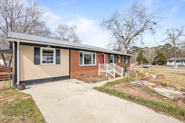 view of front of property with crawl space, brick siding, and metal roof