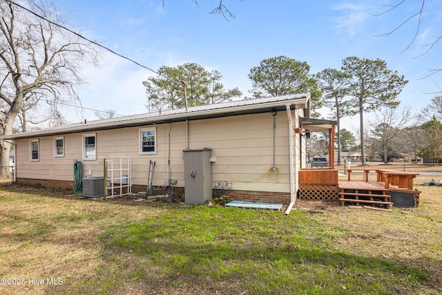 back of property featuring a yard, crawl space, metal roof, and a deck