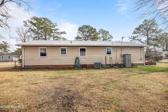 back of property with crawl space, fence, metal roof, and a yard